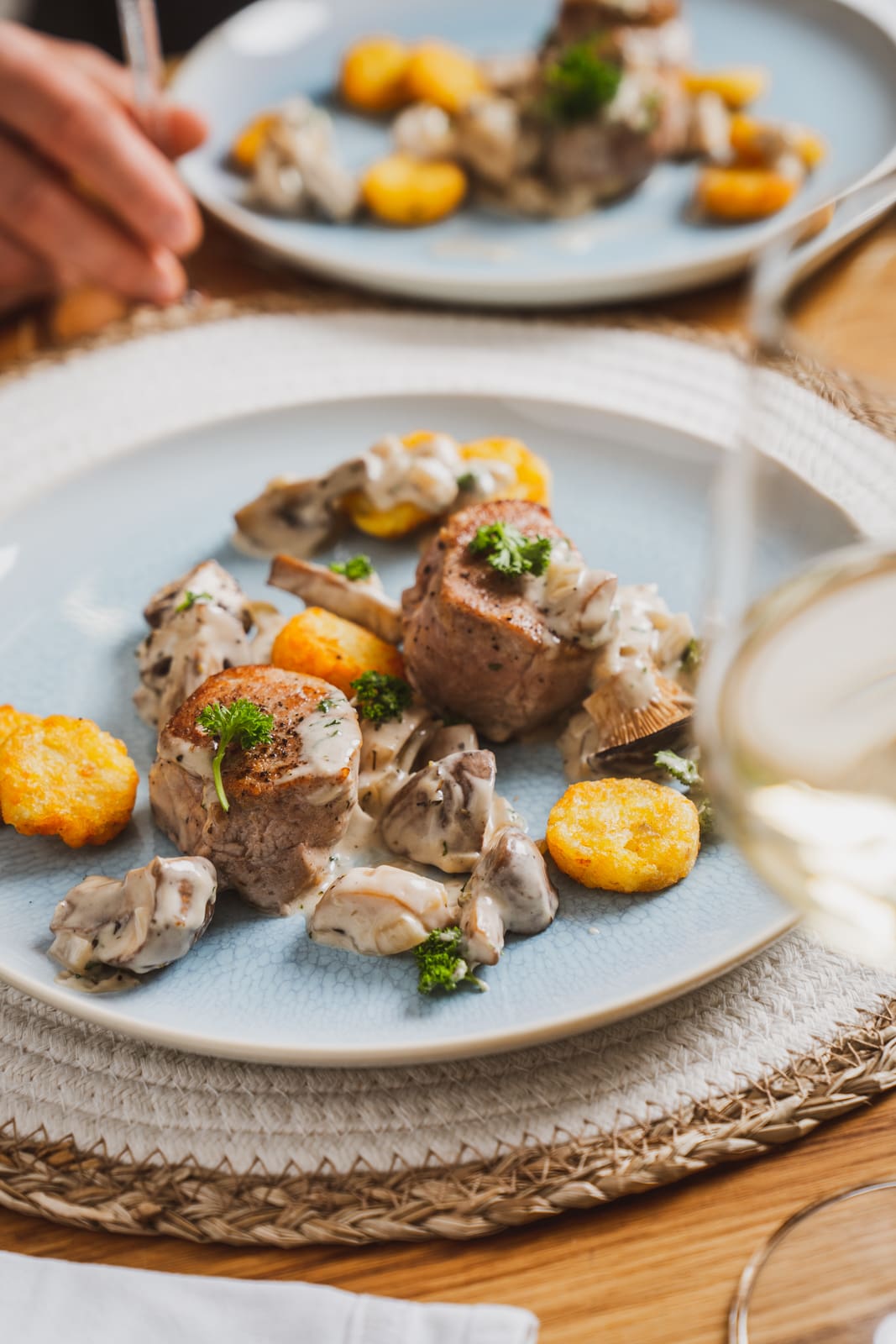 Schweinemedaillons in Champignonrahmsoße. Unser liebstes Sonntagsessen 4 Teller mit Schweinemedaillons in Champignonrahmsoße und kleinen Rösti